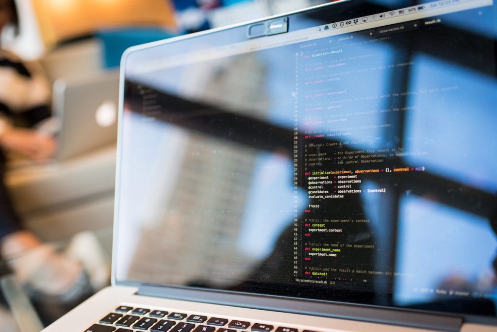 Photograph of a laptop screen with code