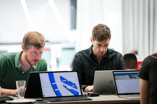 Photograph of two participants sat at laptops as part of the G-Research Engineering Hackathon