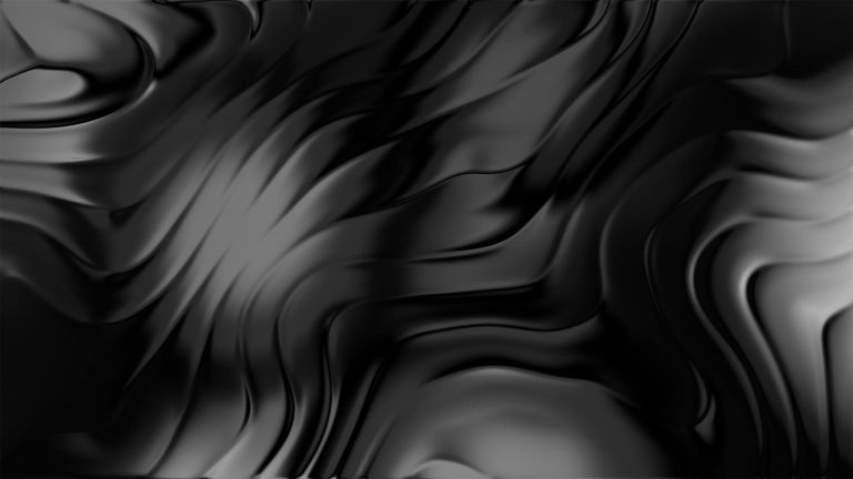 Silky black fabric flowing in smooth undulating waves across a flat plane creating soft highlights and shadows in a dim abstract setting